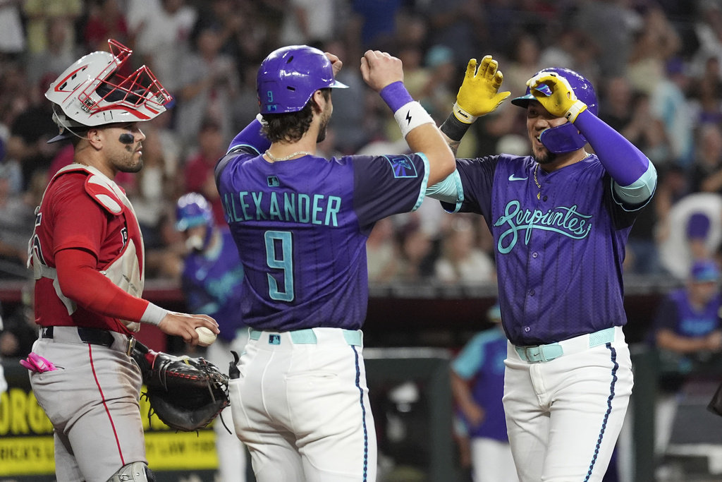 Arizona Diamondbacks' Ildemaro Vargas, right, celebrates his three-run home run with Diamondbacks' Blaze Alexander (9) as Boston Red Sox catcher Carlos Narváez, left, pauses at home plate during the third inning of a baseball game Friday, Sept. 5, 2025, in Phoenix. (AP Photo/Ross D. Franklin)