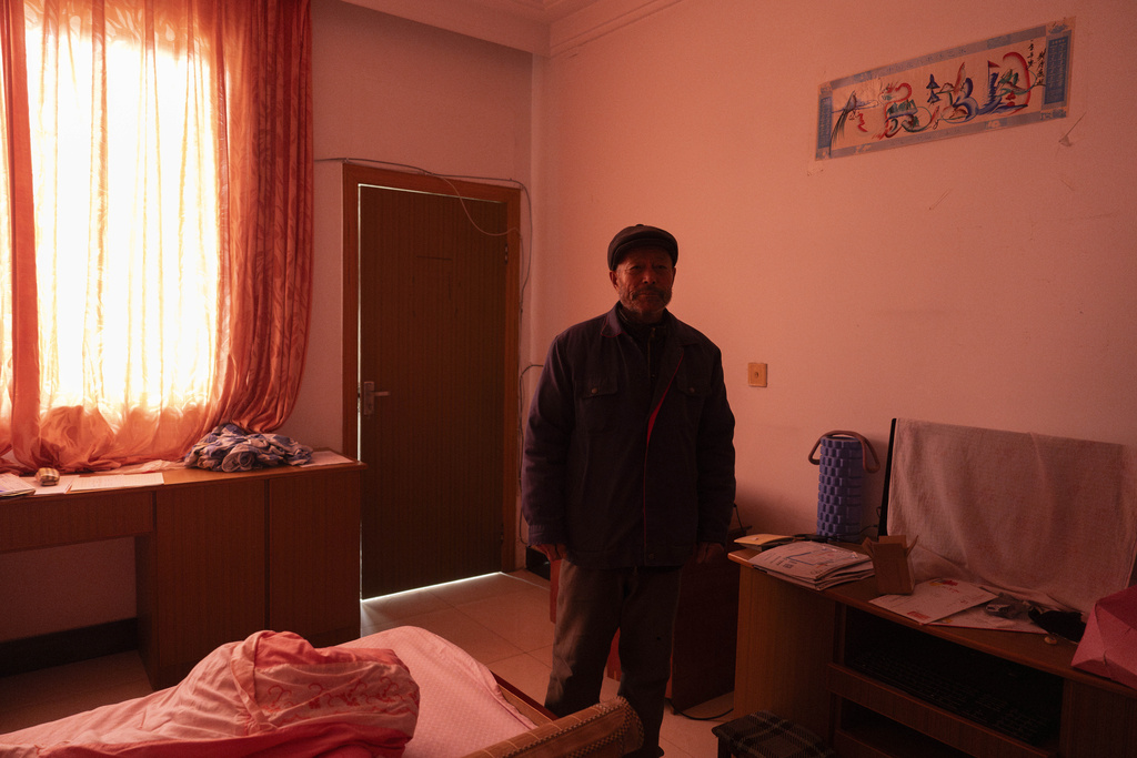 Petitioner Yang Guoliang stands in the room of his daughter, who has since been detained, which is covered with curtains for privacy from nearby police surveillance cameras in Changzhou in eastern China's Jiangsu Province on Friday, Dec. 13, 2024. (AP Photo/Ng Han Guan)