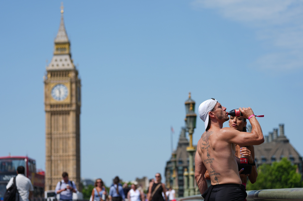 A man drinks on Westminster Bridge in London, as a heat wave is predicted Tuesday, June 23, 2026. (AP Photo/Kirsty Wigglesworth)