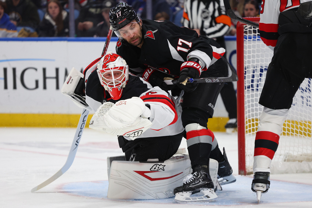 Buffalo Sabres left wing Jason Zucker (17) collides with New Jersey Devils goaltender Jake Allen, left, during the first period of an NHL hockey game Friday, Nov. 28, 2025, in Buffalo, N.Y. (AP Photo/Jeffrey T. Barnes)