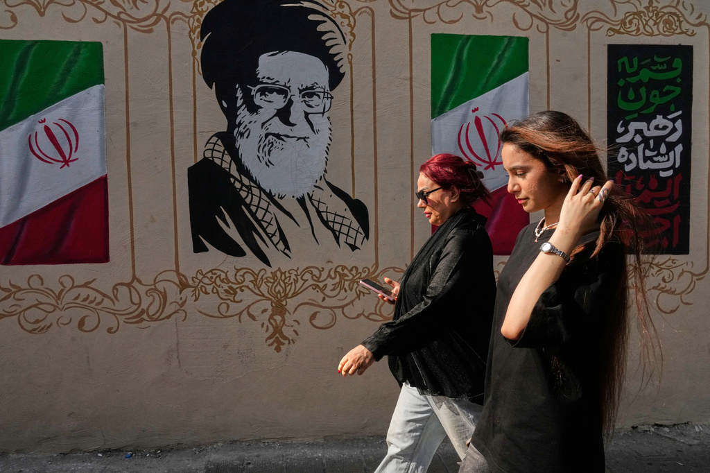 Women walk past a portrait of the late Iranian Supreme Leader Ayatollah Ali Khamenei, who was killed in the U.S. and Israel strike on Feb. 28, and images of the Iranian flag, on a sidewalk in downtown Tehran, Iran, Thursday, Aug. 20, 2026. (AP Photo/Vahid Salemi)