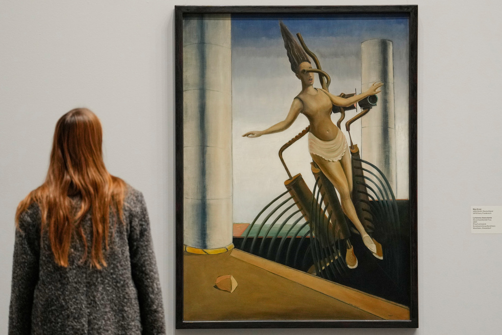 A woman looks at the artwork "The Wavering Woman" by artist Max Ernst at the new exhibition "Queer Modernism. 1900 to 1950" at the Kunstsammlung NRW museum in Duesseldorf, Germany, highlighting the contributions of queer artists to modernism. (AP Photo/Martin Meissner)