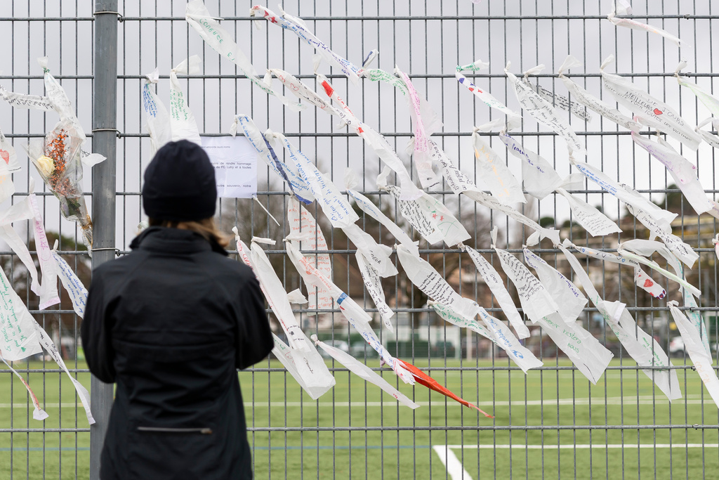 Flowers and messages have been placed in tribute to the young members of FC Lutry who died in Crans-Montana following the fire at the "Le Constellation" bar, at the football stadium in Lutry, Switzerland, Saturday, Jan. 10, 2026. (Cyril Zingaro/Keystone via AP)