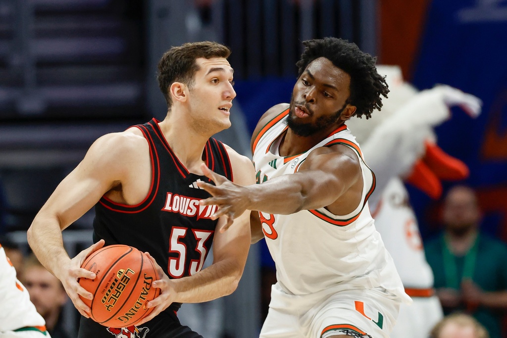Louisville forward Vangelis Zougris (53) looks to pass against Miami center Ernest Udeh Jr. during the first half of an NCAA college basketball game in the quarterfinals of the Atlantic Coast Conference tournament in Charlotte, N.C., Thursday, March 12, 2026. (AP Photo/Nell Redmond)