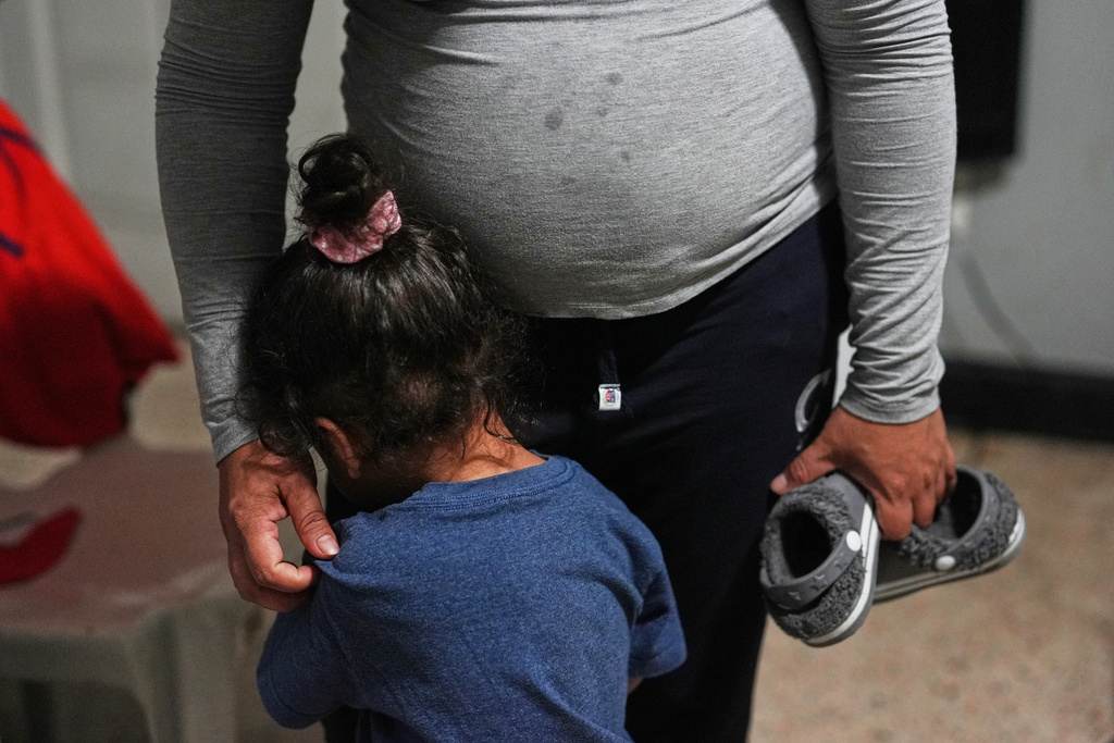 Pregnant asylum-seeker Yaoska, 32, comforts her two-year-old son who was not feeling well, inside the Miami-area motel room where she and her two children are living after her husband was deported to Nicaragua, Thursday, Nov. 13, 2025. (AP Photo/Rebecca Blackwell)