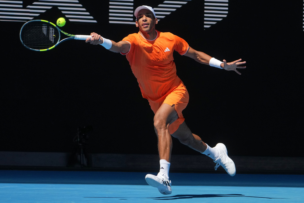 Felix Auger-Aliassime of Canada plays a forehand return to Nuno Borges of Portugal during their first round match at the Australian Open tennis championship in Melbourne, Australia, Monday, Jan. 19, 2026. (AP Photo/Asanka Brendon Ratnayake)