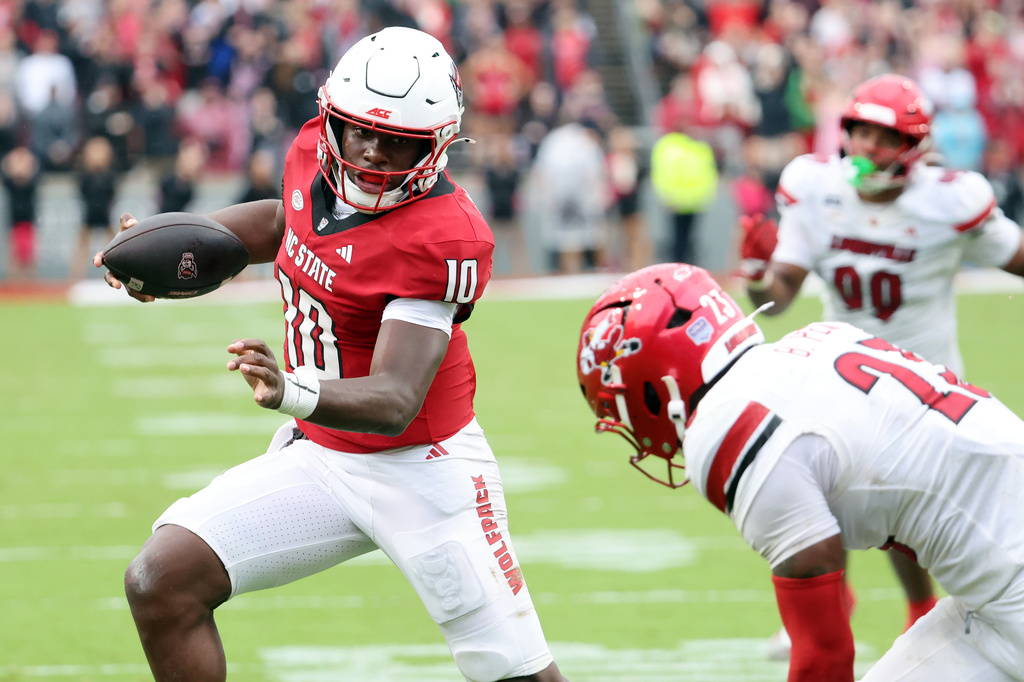 North Carolina State's Will Wilson (10) runs away from Louisville's Ben Perry (23) during the first half of an NCAA college football game in Raleigh, N.C., Saturday, Oct. 3, 2026. (AP Photo/Karl DeBlaker)