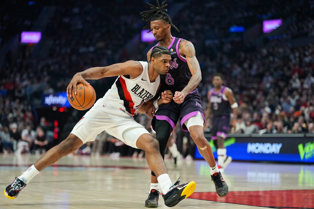 Portland Trail Blazers guard Scoot Henderson, left, drives to the basket as Minnesota Timberwolves guard Bones Hyland (8) defends during the first half of an NBA basketball game, Tuesday, Feb. 24, 2026, in Portland, Ore. (AP Photo/Jenny Kane)