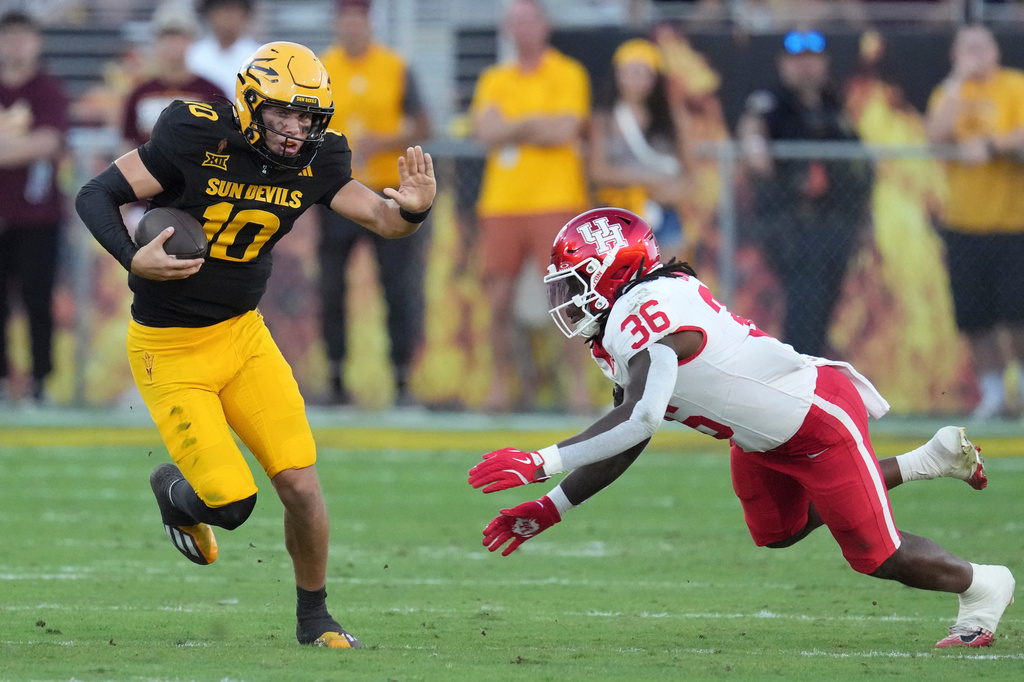 FILE - Arizona State quarterback Sam Leavitt (10) runs past Houston linebacker Jalen Garner (36) during the first half of an NCAA college football game, Oct. 25, 2025, in Tempe, Ariz. (AP Photo/Ross D. Franklin, File)