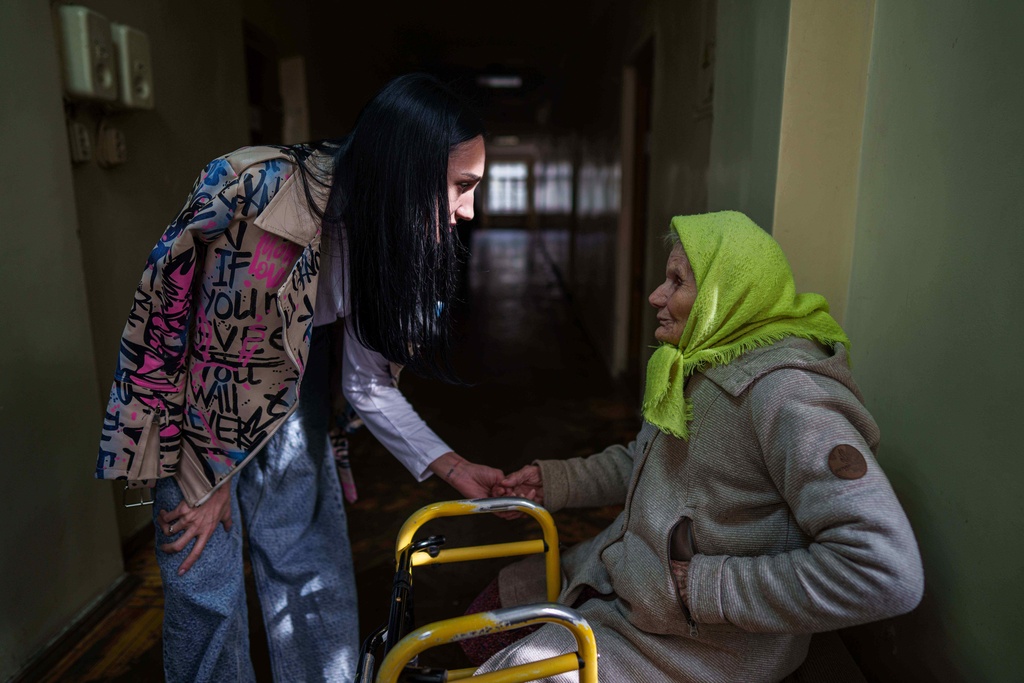 Psychologist Veronika Chumak speaks to Oleksandra Bezshapko, 91, at a hostel for the displaced in Dnipro, Ukraine, Wednesday, Oct. 8, 2025. (AP Photo/Evgeniy Maloletka)