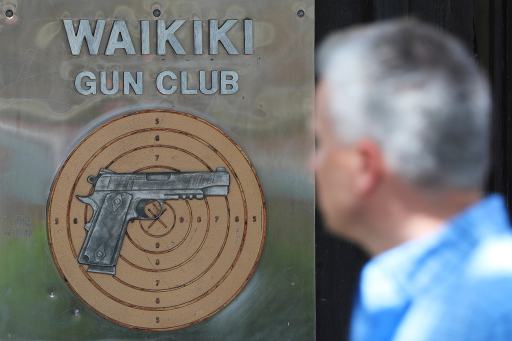 FILE - People walk past the Waikiki Gun Club, Thursday, June, 23, 2022 in Honolulu. (AP Photo/Marco Garcia)