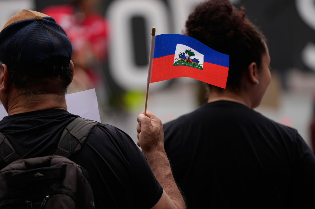 People hold Haitian flags and signs during a rally in support of immigrants living in the United States with temporary protected status, or TPS, Thursday, July 9, 2026, in San Diego. (AP Photo/Gregory Bull)