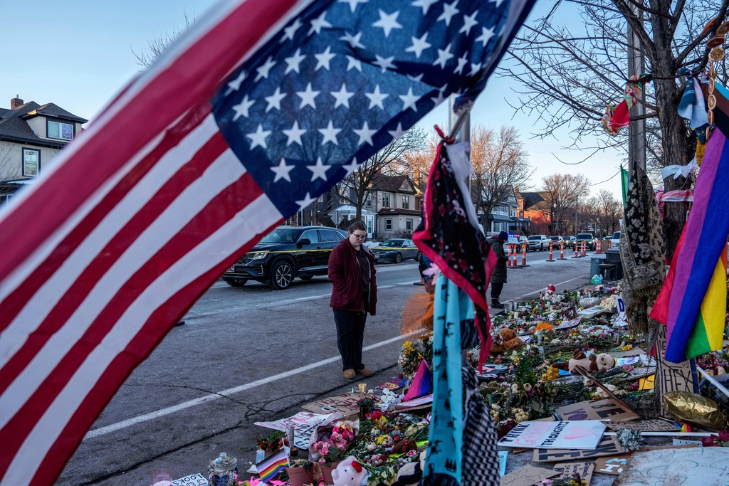 People visit a makeshift memorial for Renee Good, who was fatally shot by an ICE officer last week, Wednesday, Jan. 14, 2026, in Minneapolis. (AP Photo/Adam Gray)