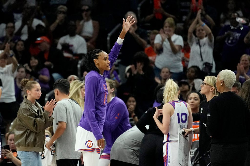 Phoenix Mercury forward DeWanna Bonner waves to the crowd after it was announced Bonner had scored her 8,000th point during the second half of a WNBA basketball game against the Chicago Sky, Tuesday, July 7, 2026, in Phoenix. (AP Photo/Ross D. Franklin)