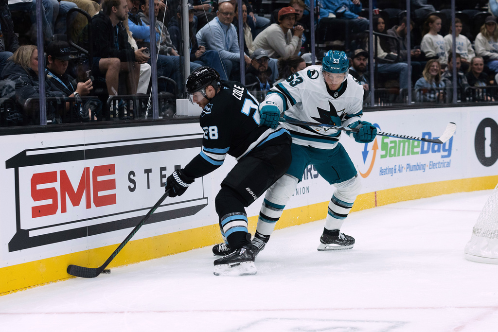 Utah Mammoth defenseman Ian Cole (28) fights for the puck against San Jose Sharks left wing Jeff Skinner (53) during the first period of an NHL hockey game Friday, Oct. 17, 2025, in Salt Lake City. (AP Photo/Melissa Majchrzak)