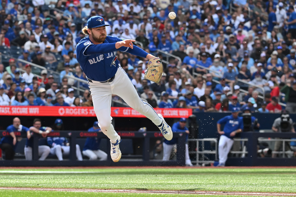 Toronto Blue Jays pitcher Spencer Miles (62) throws to first base after fielding a bunt off the bat of Cincinnati Reds' Carlos Jorge, who was safe, during the third inning of a baseball game in Toronto, Saturday, Sept. 26, 2026. (Jon Blacker/The Canadian Press via AP)