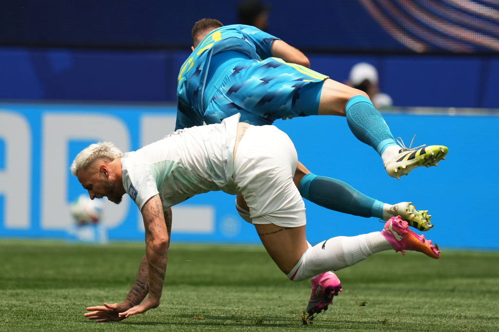 Spain goalkeeper Unai Simon and Austria's Marko Arnautovic fall during a World Cup round of 32 soccer match in Inglewood, Calif., near Los Angeles, Thursday, July 2, 2026. (AP Photo/Andre Penner)