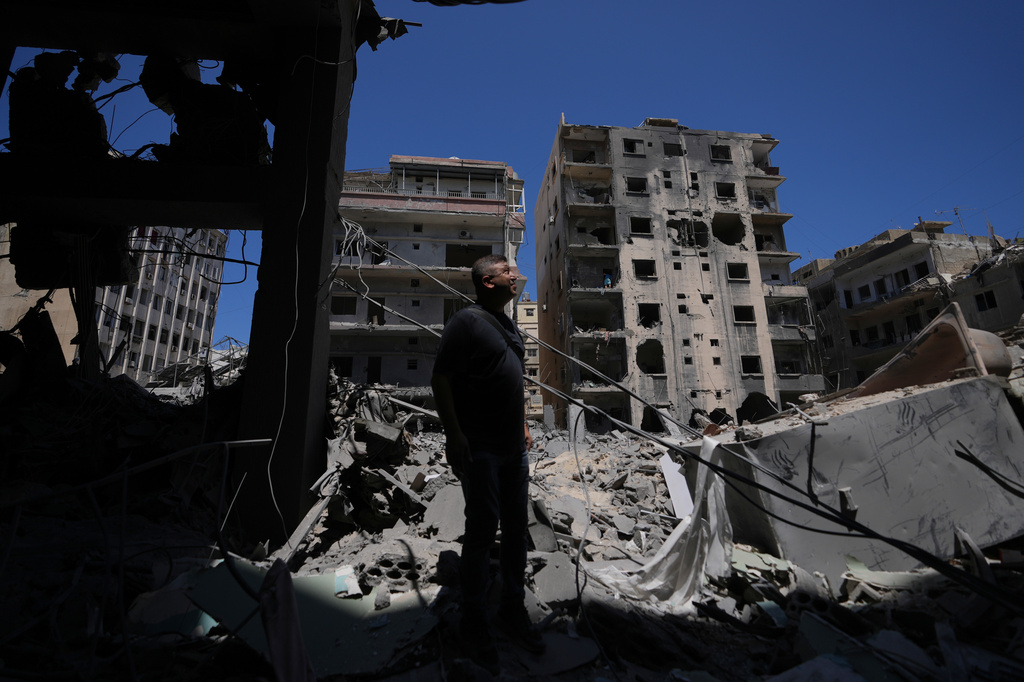 Resident Adnan Kaour stands amid debris outside his apartment building, which was damaged in Israeli strikes in the southern port city of Tyre, Lebanon, Thursday, June 18, 2026. (AP Photo/Hassan Ammar)