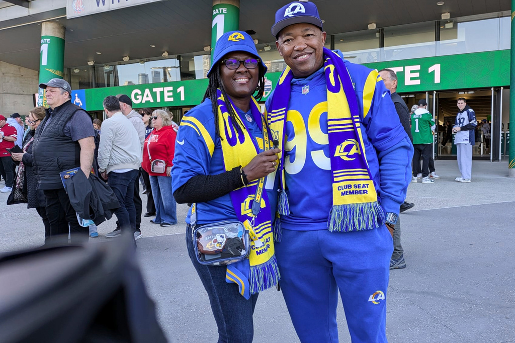 Dorcas and Nick Mwangi pose for a photo outside the Melbourne Cricket Ground ahead of the Los Angeles Rams and San Francisco 49ers NFL football game in Melbourne, Australia, Friday, Sept. 11, 2026. (AP Photo/Lincoln Tracy)