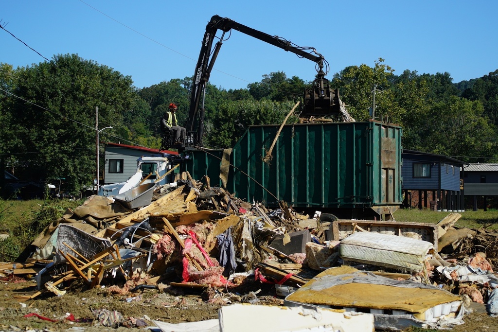 FILE -A claw operator scoops up debris from homes demolished following Hurricane Helene in Old Fort, N.C., on Thursday, Sept. 11, 2025. (AP Photo/Allen G. Breed, File)