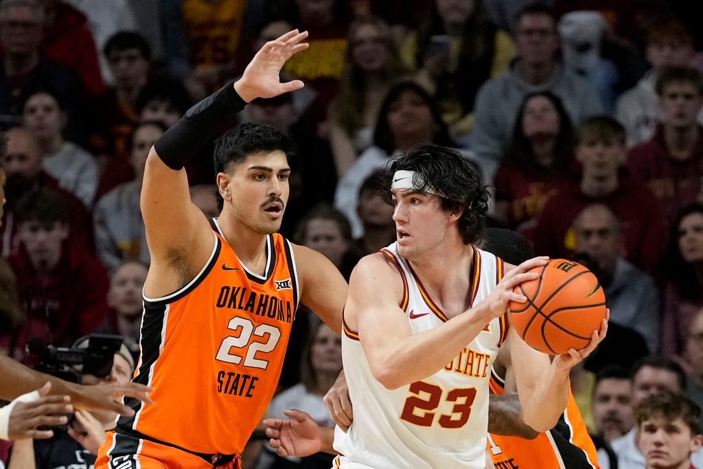 Iowa State forward Blake Buchanan (23) looks to pass around Oklahoma State center Parsa Fallah (22) during the first half of an NCAA college basketball game, Saturday, Jan. 10, 2026, in Ames, Iowa. (AP Photo/Charlie Neibergall)
