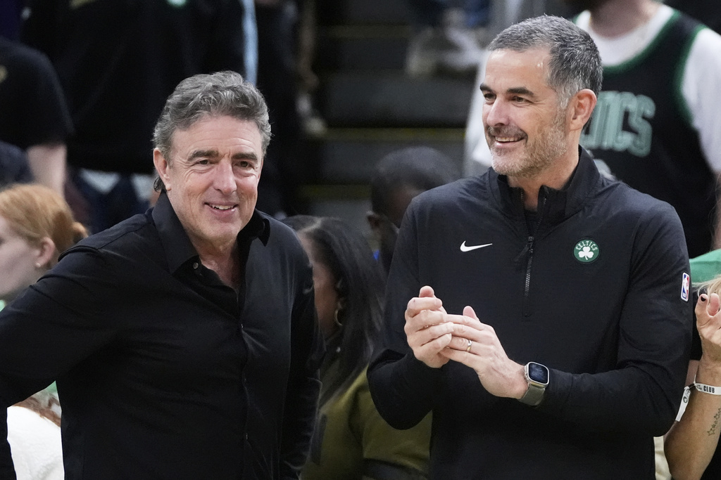 FILE - Boston Celtics co-owner Wyc Grousbeck, left, stands with William Chisholm, right, who agreed to buy the team for about $6 billion last month, during the first half of an NBA basketball game against the Phoenix Suns, Friday, April 4, 2025, in Boston. (AP Photo/Charles Krupa, file)