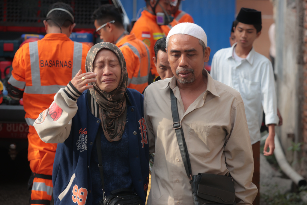 A woman weeps as rescue work is underway after a building under construction collapsed at an Islamic boarding school in Sidoarjo, East Java, Indonesia, Tuesday, Sept. 30, 2025. (AP Photo/Trisnadi)