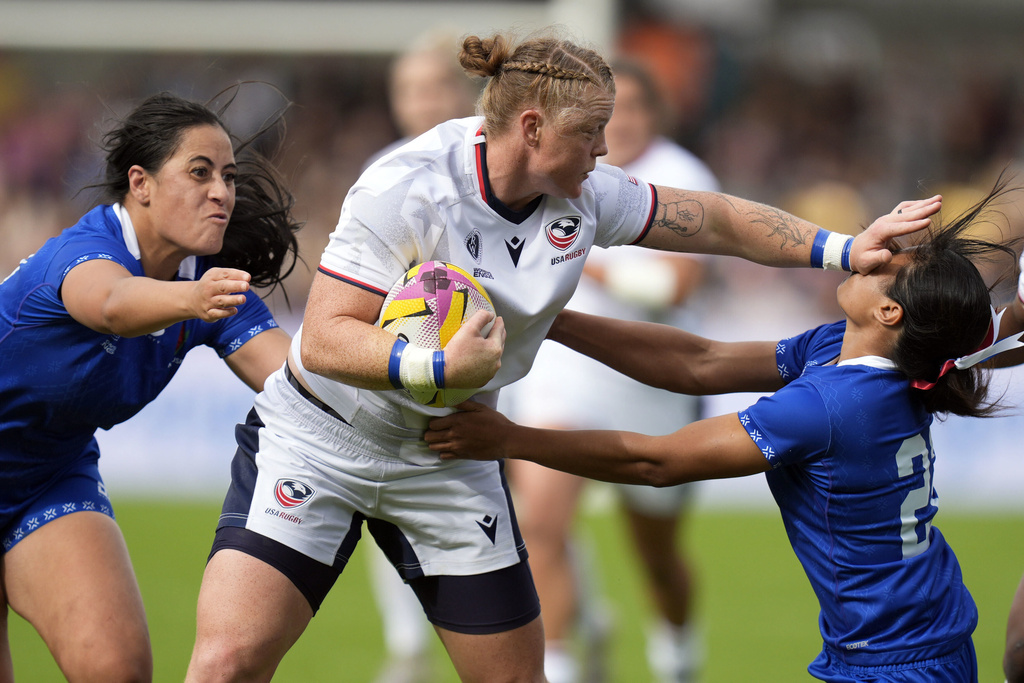 USA's Alev Kelter, center, and Samoa's Faalua Tugaga, right, challenge for the ball during the Women's Rugby World Cup 2025 Pool A match between USA and Samoa in York, England, Saturday, Sept. 6, 2025. (Danny Lawson/PA via AP)