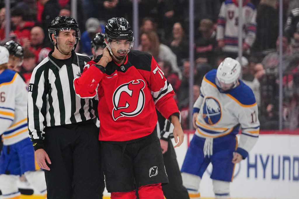 New Jersey Devils' Jack Hughes (86) drives past Buffalo Sabres' Jack Quinn (22)during the second period of an NHL hockey game Wednesday, Feb. 25, 2026, in Newark, N.J. (AP Photo/Frank Franklin II)
