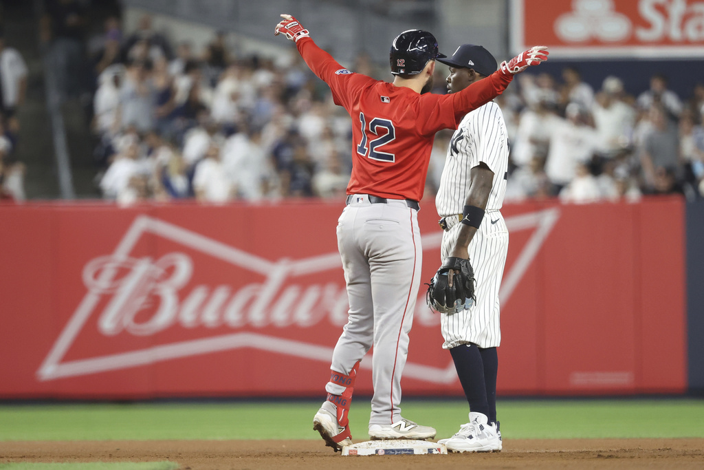 Boston Red Sox's Connor Wong, left, reacts next to New York Yankees second baseman Jazz Chisholm Jr., right, after hitting a double, leading Nathaniel Lowe to score, during the seventh inning of a baseball game Friday, Aug. 22, 2025, in New York. (AP Photo/Pamela Smith)