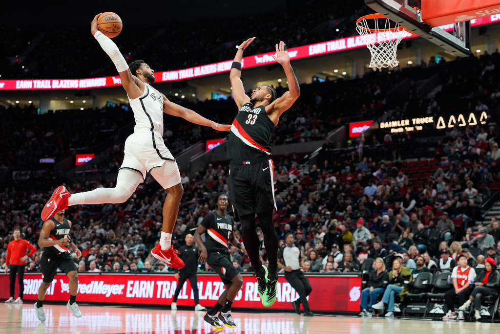 Brooklyn Nets guard/forward Chaney Johnson drives to the basket as Portland Trail Blazers forward Toumani Camara (33) defends during the first half of an NBA basketball game Monday, March 23, 2026, in Portland, Ore. (AP Photo/Jenny Kane)