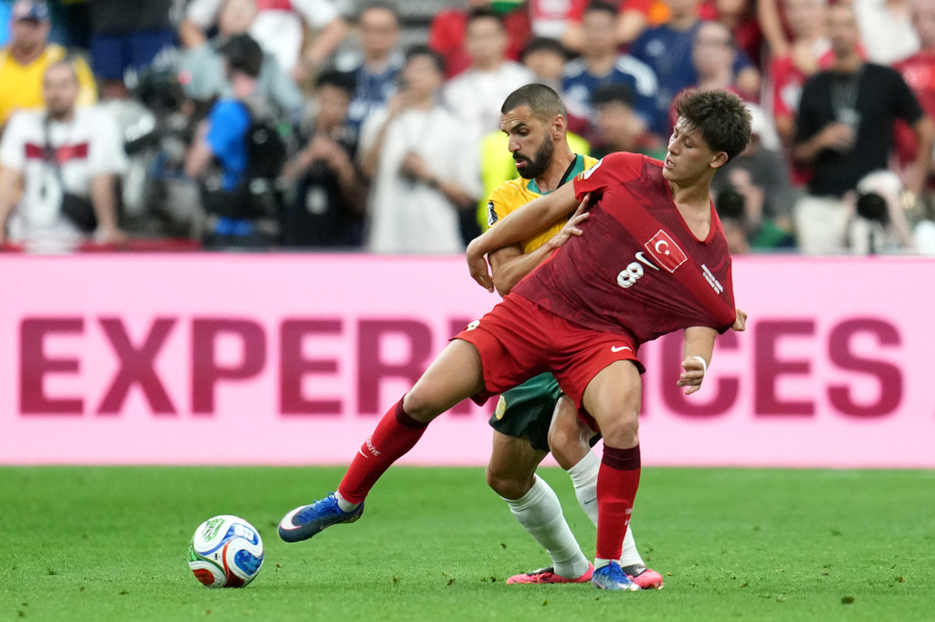 Turkey's Arda Guler (8) challenges for the ball with Australia goalkeeper Patrick Beach (18) during the World Cup Group D soccer match between Australia and Turkey in Vancouver, British Columbia, Saturday, June 13, 2026. (AP Photo/Abbie Parr)