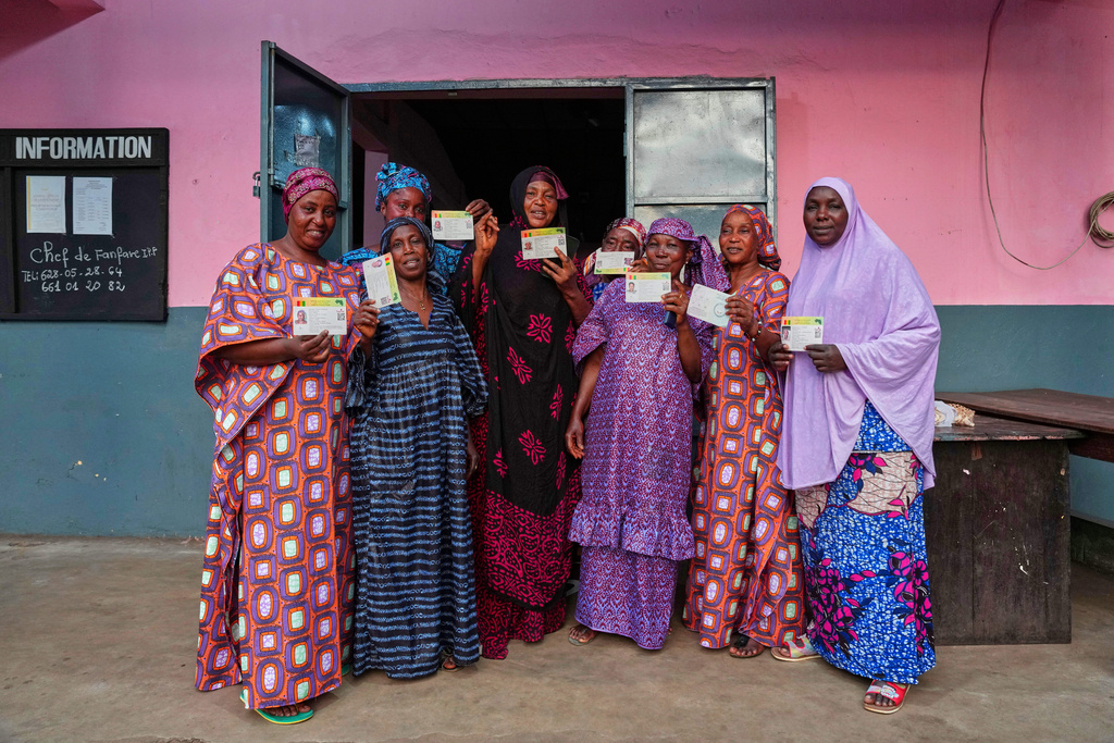 A group of women pose at a polling station after casting their votes during the constitutional referendum in Conakry, Guinea, Sunday, Sept. 21, 2025. (AP Photo/Misper Apawu)
