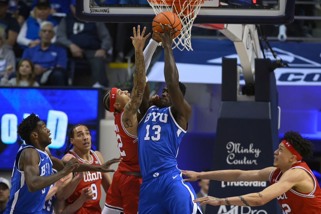 Utah guard Terrence Brown, center left, has his shot blocked by BYU center Keba Keita, center right, during the first half of an NCAA college basketball game, Saturday, Jan. 24, 2026, in Provo, Utah. (AP Photo/Tyler Tate)
