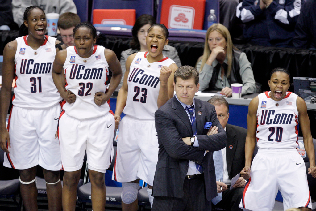 FILE - Connecticut's Tina Charles (31), Kalana Greene (32), Maya Moore (23) and Renee Montgomery (20) celebrate behind coach Geno Auriemma in the final moments of Connecticut's 83-64 win over Stanford in a semifinal of the NCAA women's college basketball tournament Final Four on Sunday, April 5, 2009, in St. Louis.. (AP Photo/Jeff Roberson, File)