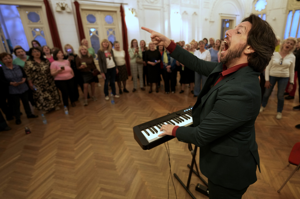 Nenad Azanjac, founder of Pop Choir, leads a song during a practice in Belgrade, Serbia, Wednesday, April 15, 2026. (AP Photo/Darko Vojinovic)
