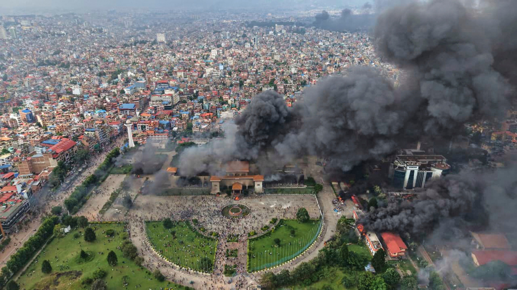 Smoke billows from the parliament building after it was set on fire during a protest against social media ban and corruption in Kathmandu, Nepal, Tuesday, Sept. 9, 2025. (AP Photo/Prakash Timalsina)