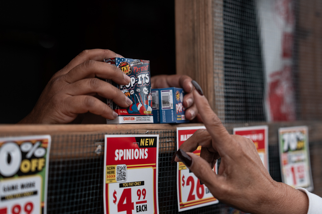 Jennifer Aragon, left, shows fireworks packages to a customer at a TNT Fireworks stand in Alhambra, Calif., Tuesday, June 30, 2026, ahead of the Fourth of July holiday. (AP Photo/Jae C. Hong)