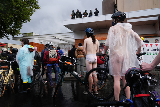 Federal agents stand and look over protesters during the Naked Bike Ride protest at the U.S. Immigration and Customs Enforcement facility on Sunday, Oct. 12, 2025, in Portland, Ore. (AP Photo/Jenny Kane) Federal agents stand and look over protesters during the Naked Bike Ride protest at the U.S. Immigration and Customs Enforcement facility on Sunday, Oct. 12, 2025, in Portland, Ore. (AP Photo/Jenny Kane)