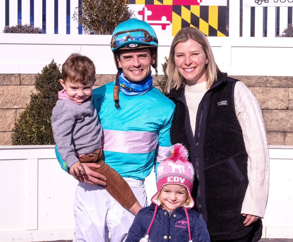 In this image provided by the The Maryland Jockey Club, husband and wife, jockey Sheldon Russell and trainer Brittany Russell, pose for a photo in the winner's circle with son Rye and daughter Edy, after Point Dume won the third race, Dec. 31, 2023, at Laurel Park in Laurel, Md. (Jim McCue/The Maryland Jockey Club via AP)