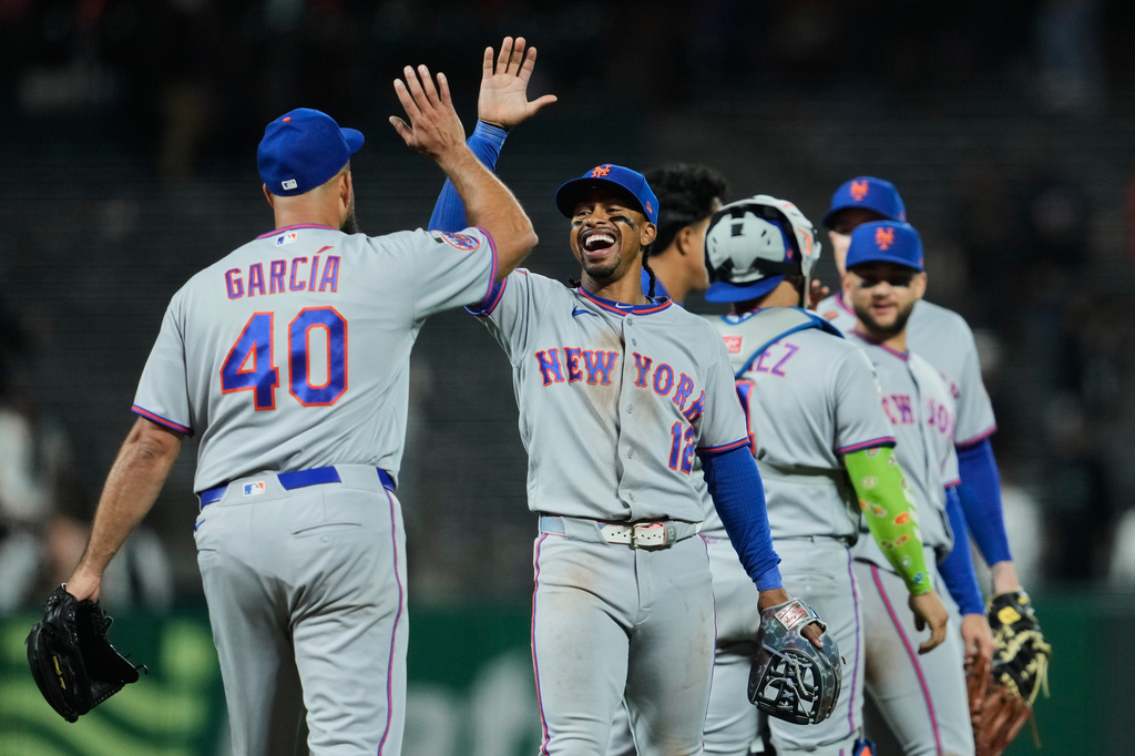 New York Mets shortstop Francisco Lindor (12) and pitcher Luis García (40) celebrate after the team's victory over the San Francisco Giants in a baseball game Friday, April 3, 2026, in San Francisco. (AP Photo/Godofredo A. Vásquez)