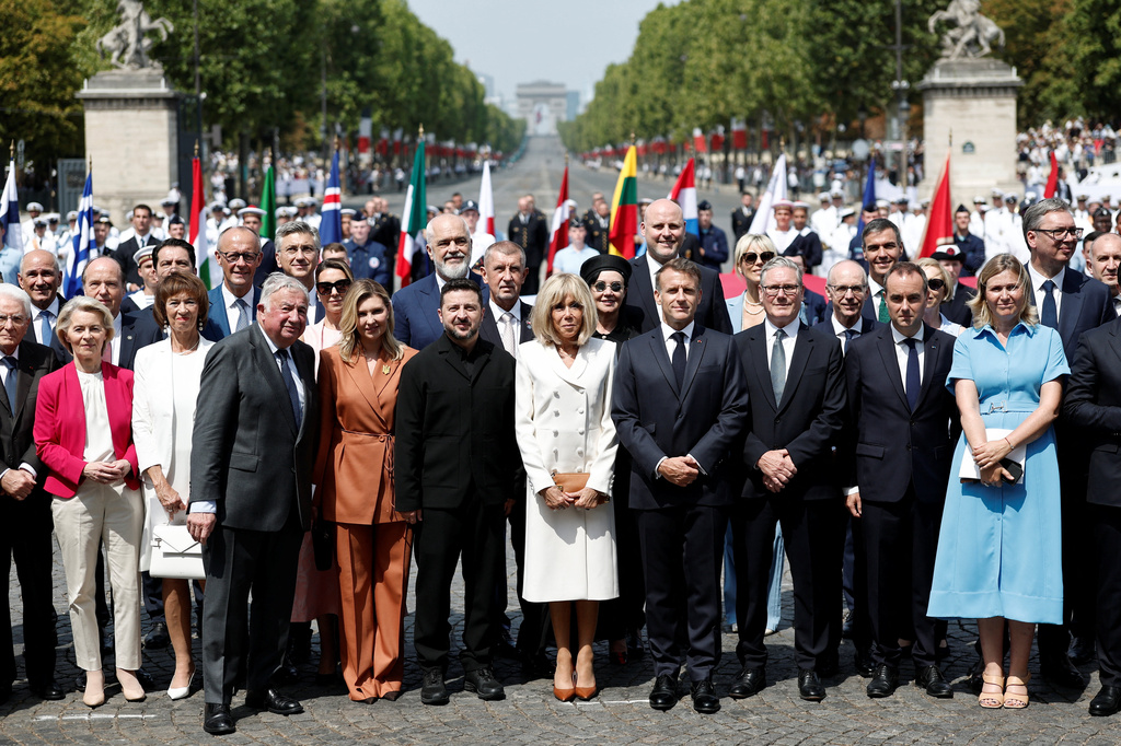 French President Emmanuel Macron, his wife Brigitte Macron, Ukraine's President Volodymyr Zelenskyy and his wife Olena Zelenska, Heads of State and Government of the Coalition of the Willing, President of the National Assembly Yael Braun-Pivet, and President of the Senate Gerard Larcher pose for a family photo after the annual Bastille Day military parade on the Place de la Concorde in Paris, France, Tuesday, July 14, 2026. (Benoit Tessier/Pool photo via AP)