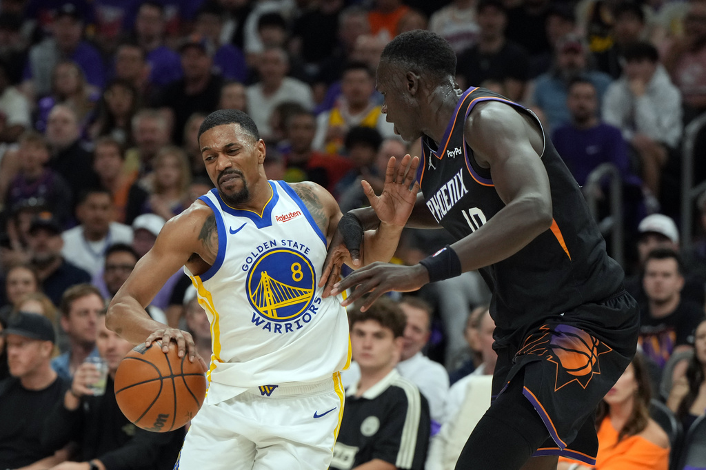 Golden State Warriors guard De'anthony Melton (8) shields the ball from Phoenix Suns center Khaman Maluach, right, during the first half of an NBA basketball play-in tournament game, Friday, April 17, 2026, in Phoenix. (AP Photo/Rick Scuteri)