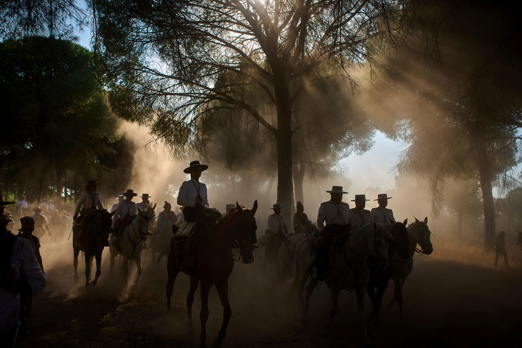 Pilgrims ride through dusty terrain, on their way to the shrine of El Rocio during the annual pilgrimage, near Aznalcázar, Spain, June 6, 2025. (AP Photo/Emilio Morenatti, File)