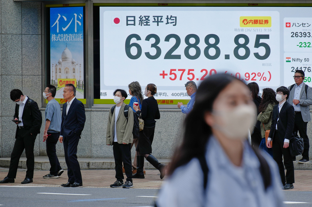 People stand in front of an electronic stock board showing Japan's Nikkei index at a securities firm Monday, May 11, 2026, in Tokyo. (AP Photo/Eugene Hoshiko)