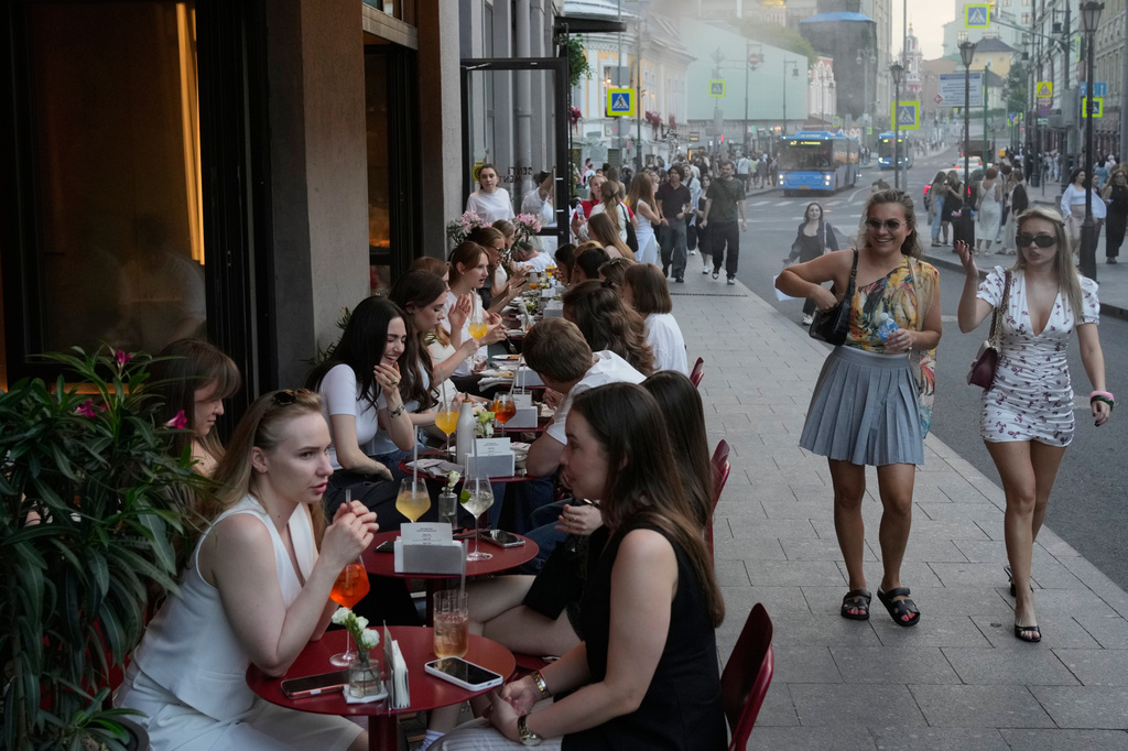 FILE - People sit at a sidewalk cafe on a hot summer day in Moscow, Friday, July 3, 2026. (AP Photo/Pavel Bednyakov, File)