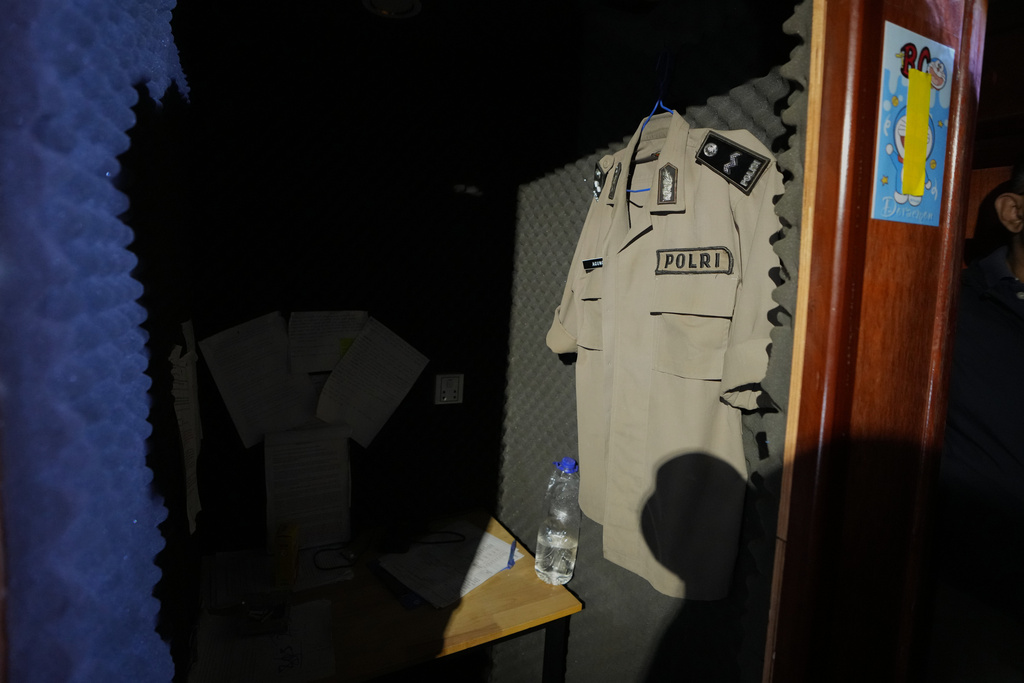 A fake Indonesian police shirt hangs inside a scam center in O'Smach, Cambodia, Monday, Feb. 2, 2026. (AP Photo/Sakchai Lalit)