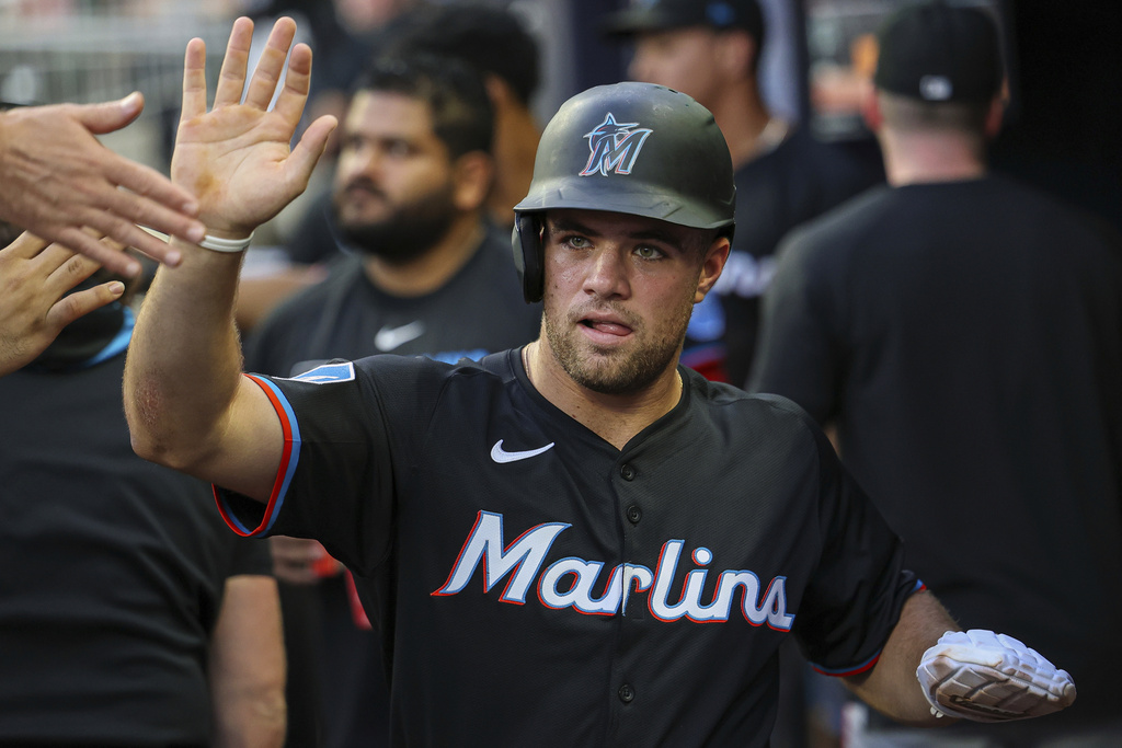 Miami Marlins' Jakob Marsee high-fives teammates in the dugout after scoring a run in the fourth inning of a baseball game against the Atlanta Braves, Friday, Aug. 8, 2025, in Atlanta. (AP Photo/Colin Hubbard)