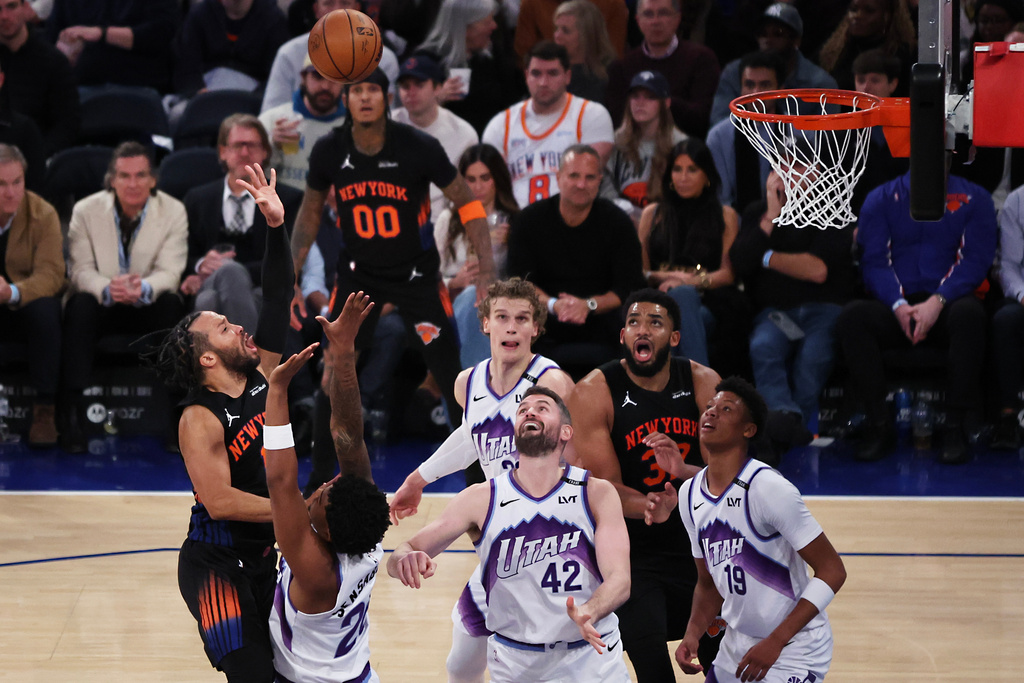New York Knicks guard Jalen Brunson, left, shoots over Utah Jazz defenders during the second half of an NBA basketball game, Friday, Dec. 5, 2025, in New York. (AP Photo/Heather Khalifa)