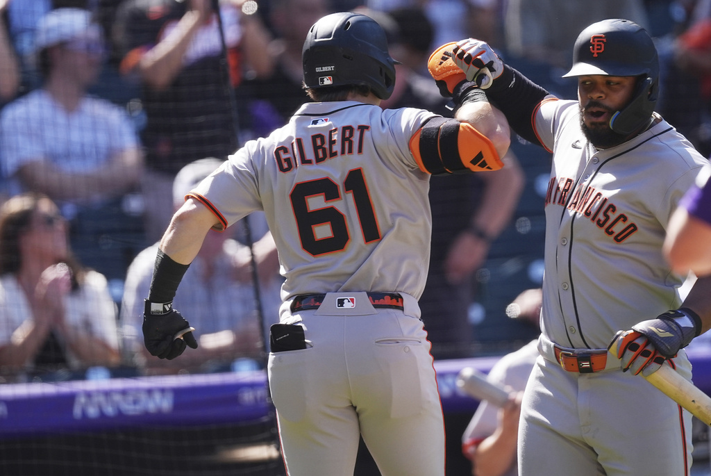 San Francisco Giants' Heliot Ramos, right, congratulates Drew Gilbert(61) who returns to the dugout after hitting a two-run home run off Colorado Rockies starting pitcher Chase Dollander in the third inning of a baseball game Monday, Sept. 1, 2025, in Denver. (AP Photo/David Zalubowski)